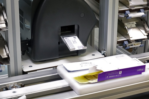 Uit een machine komt een magneetkaartje met de specificaties van de lens